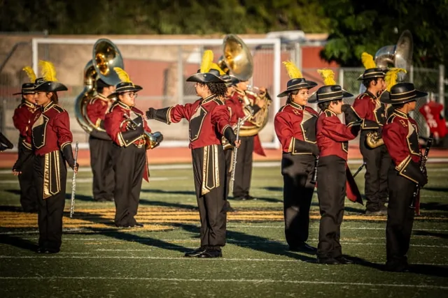 Woodwind and brass musicians performing in crimson uniforms at the Wilson Field Tournament on October 24, 2026