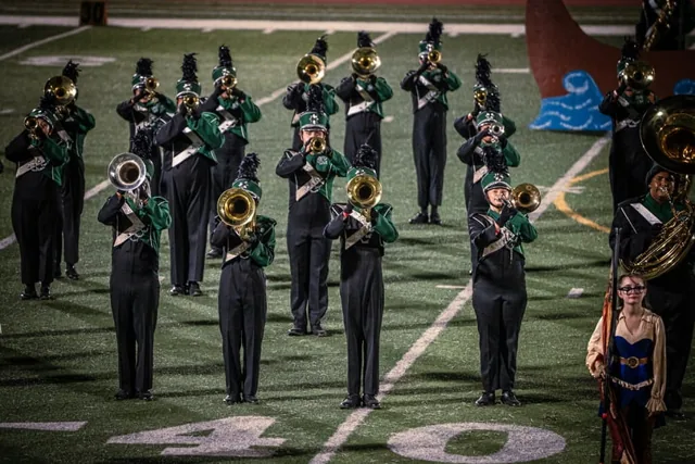 Woodwind musicians in green and black marching across the field at the Wilson Field Tournament on October 24, 2026